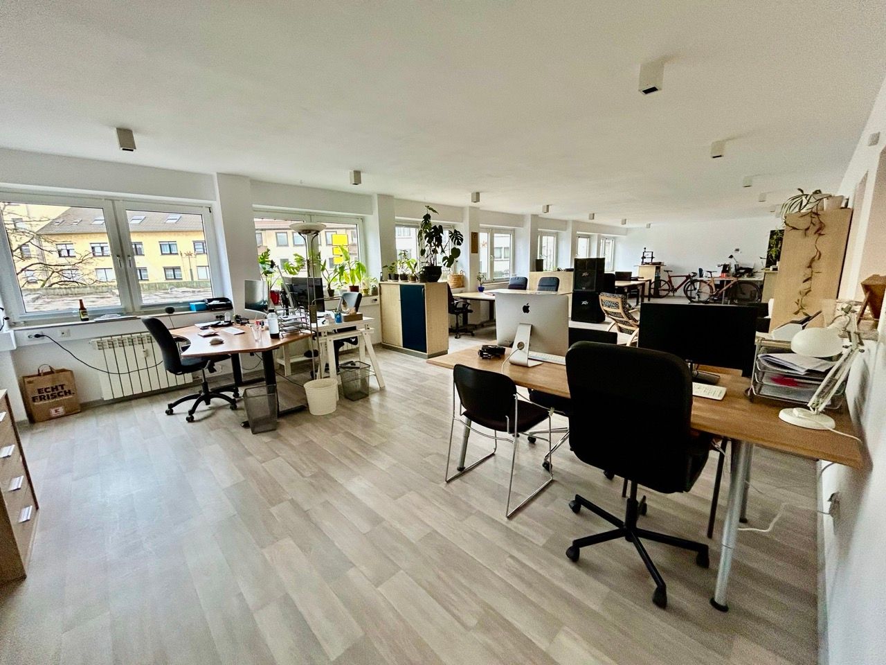 Heller Coworking-Bereich mit Schreibtischen an einer langen Fensterfront im Coworking Space Witten